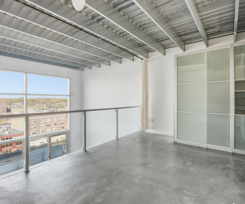 spacious modern room with industrial design large windows and glass railing showcasing city views ideal for two purposes