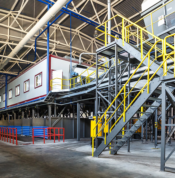 industrial interior featuring a multilevel structure with yellow staircases large windows and safety railings showcasing a modern facility for 7 efficient operations