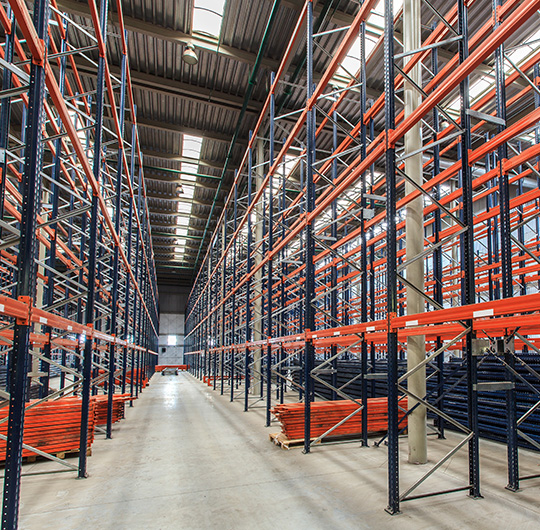 wide aisle warehouse with tall shelving units filled with storage racks and orange beams 18 storage solutions efficient organization