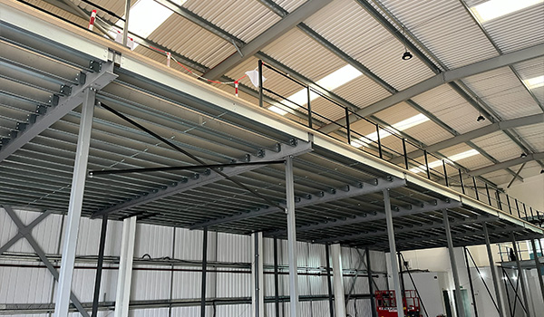 warehouse interior featuring storage mezzanine with steel framework and safety railing for optimal organization and workflow in seven distinct areas