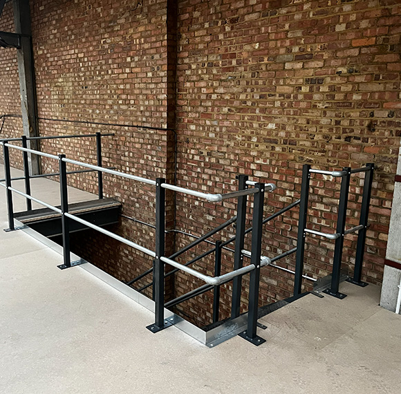 metal railing structure overlooking a staircase with brick wall background five steps to safety